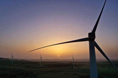 EL ROM, GOLAN HEIGHTS - MAY 19: A sunrise aerial view of new wind turbines constructed between vineyards and fruit orchards as part of the Valley of Tears (Emek Habacha) wind turbines farm project on 19 במאי 2020 near Kibbutz El Rom in Israel's Golan Heights. The project is a joint venture of the Israeli company Enlight Renewable Energy Ltd which deals in solar and wind energy in Israel and Europe, Aveeram and Dr. Eli Ben Dov. The 34 General Electric turbines, which will generate a total installed capacity of 108 GW of sustainable energy, are sited on agricultural land of nearby five kibbutz farming communities and agricultural activity will continue concurrently with the operation of the turbines. The turbine's hub height is about 86 meters above ground level, its three blades are 51.5 meters long and weigh some 17 metric tons each. The project is expected to come online in 2021 and at full capacity will supply environmentally friendly electricity to some 40,000 households in Israel, thereby reducing air pollution in Israel nearly 200,000 tons of carbon dioxide a year. (Photo by David Silverman/Getty Images)