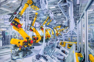 Automated robotic arms assembling car parts on a high-tech automotive production line in a modern factory