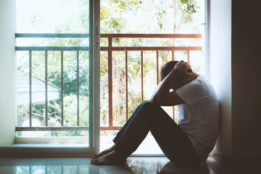 Sadness man looking through window in Dramatic concept